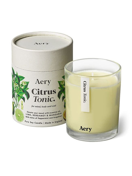 Cream Citrus Tonic candle by Aery displayed next to product packaging on white bacground 