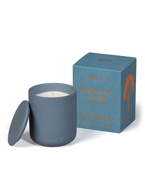 Blue Japanese Garden candle by Aery displayed next to product packaging on white bacground 
