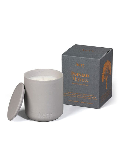 Grey Persian Thyme candle by Aery displayed next to product packaging on white bacground 