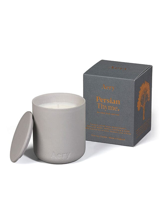 Grey Persian Thyme candle by Aery displayed next to product packaging on white bacground 