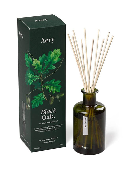 Green Black Oak diffuser by Aery displayed next to product packaging on white bacground 