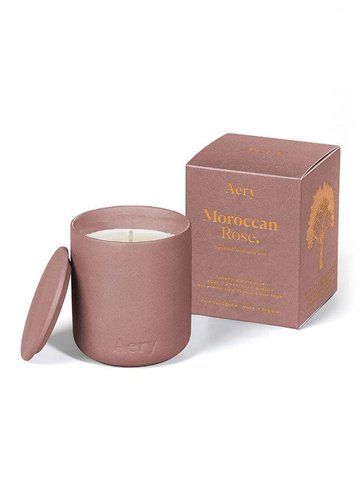 Aubergine Moroccan Rose candle by Aery displayed next to product packaging on white bacground 