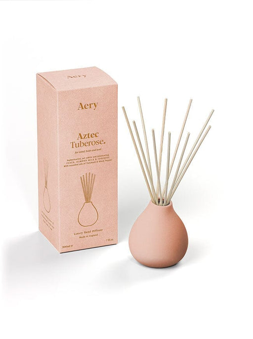 Pink Aztec Tuberose diffuser by Aery displayed next to product packaging on white bacground 