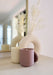 Aubergine moroccan rose candle by aery displayed next to Himalayan candle by aery sat on cream side table 