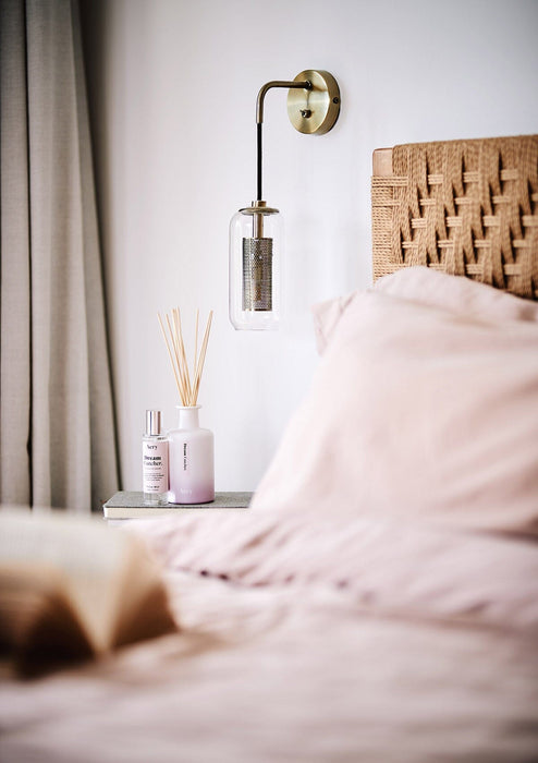 Lilac Dream Catcher pillow mist by Aery displayed next to Dream Catcher reed diffuser sat on bedside table 