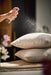 Pink Happy Space room mist by aery displayed in hand spraying onto pillows 