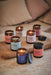 collection of aromatherapy jar candles displayed on wooden tray 